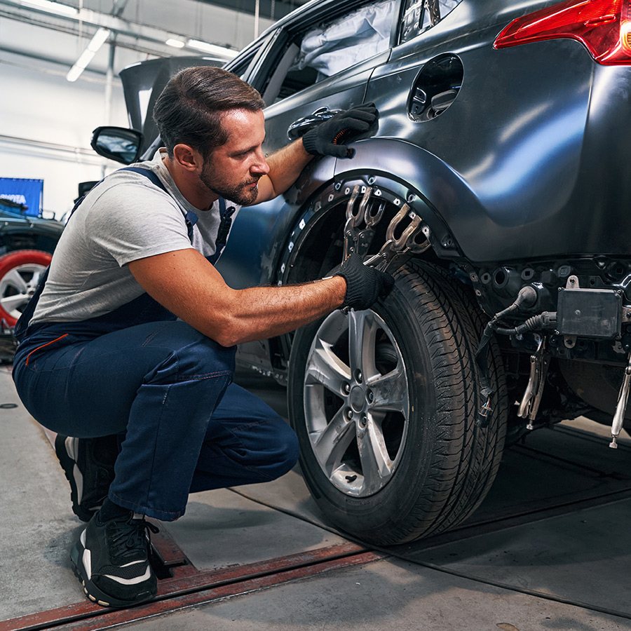 Technician refitting a wheel after body repair